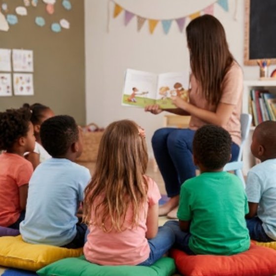 Вихователька читає дітям книжку